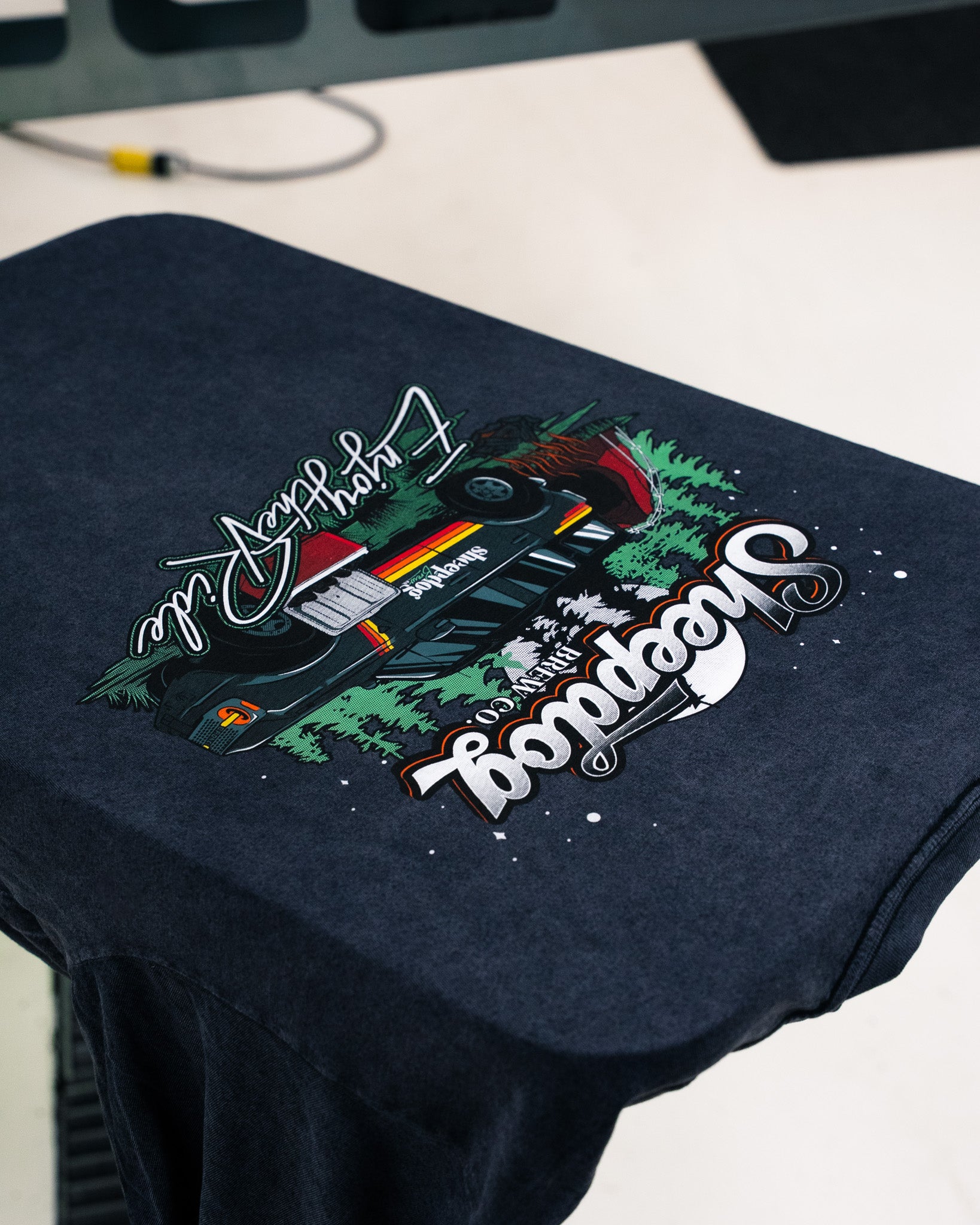 A dark t-shirt featuring a colorful graphic of a car and the word 'Swoopdog'.