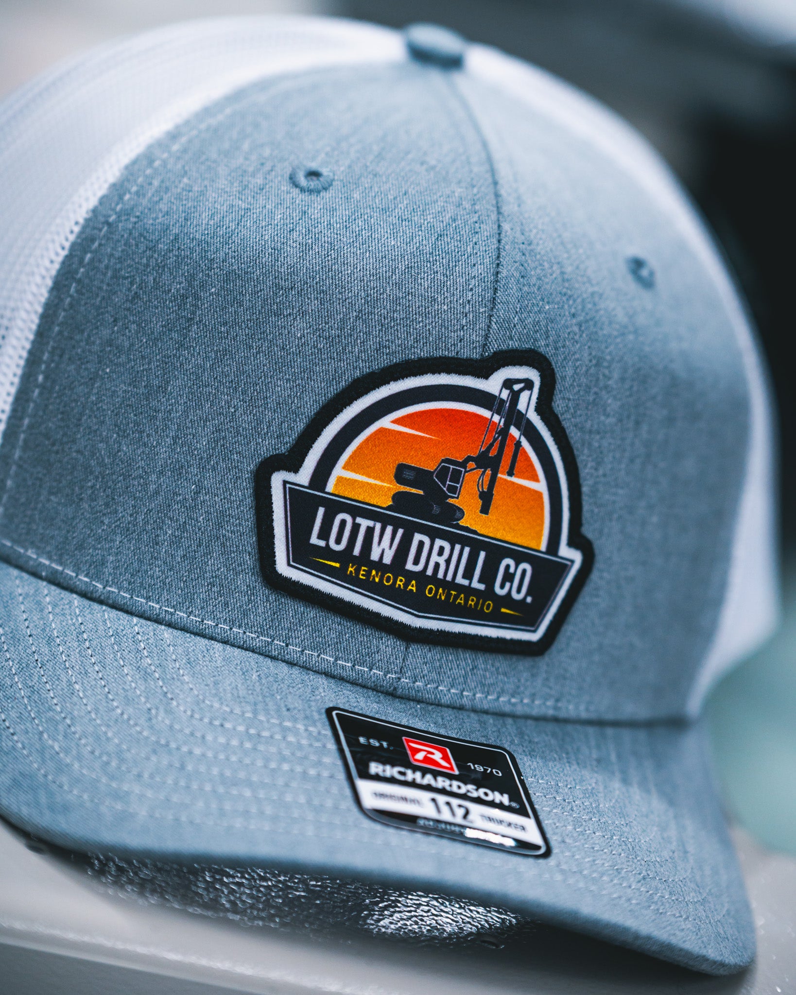 Light grey and white Richardson 112 snapback hat with custom embroidered patch for LOTW Drill Co. Kenora Ontario, produced in Winnipeg Manitoba Canada by Rogue Lab
