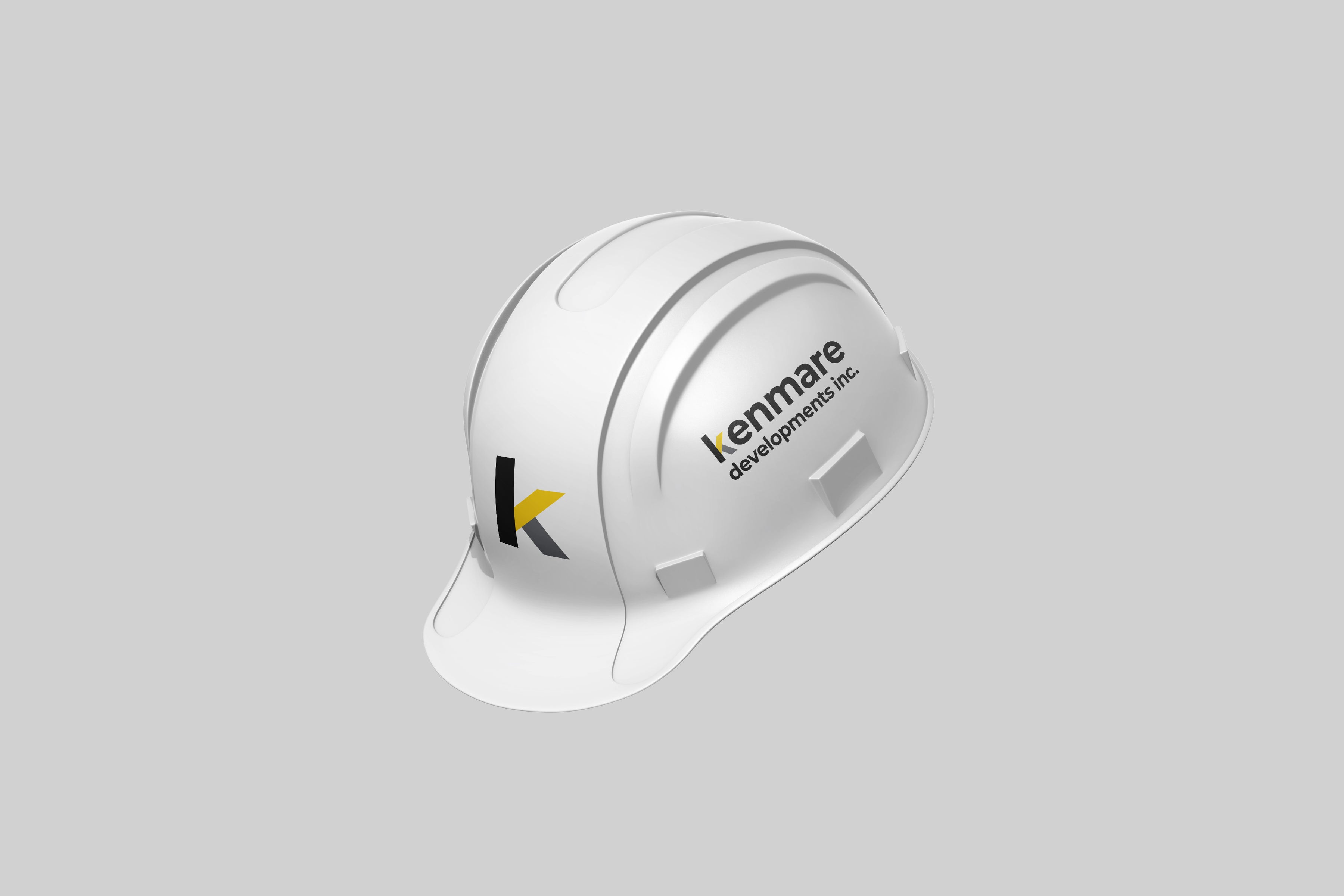 Custom hard hat decals featuring the Kenmare Developments Inc. logo, professionally printed and applied in Winnipeg by Rogue Lab.
