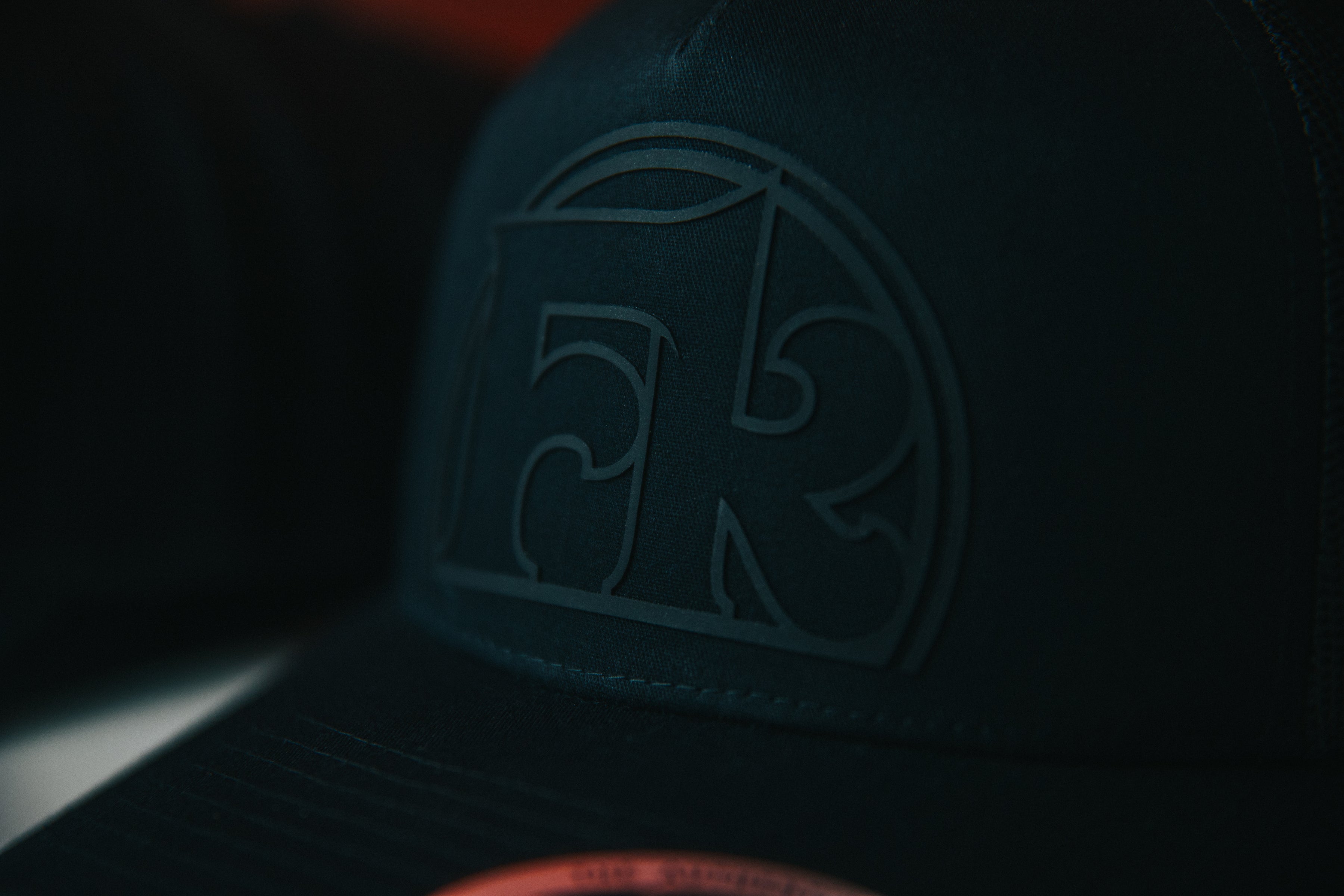 Black snapback hat with custom raised 3D rubber patch logo, manufactured in Winnipeg Manitoba Canada by Rogue Lab
