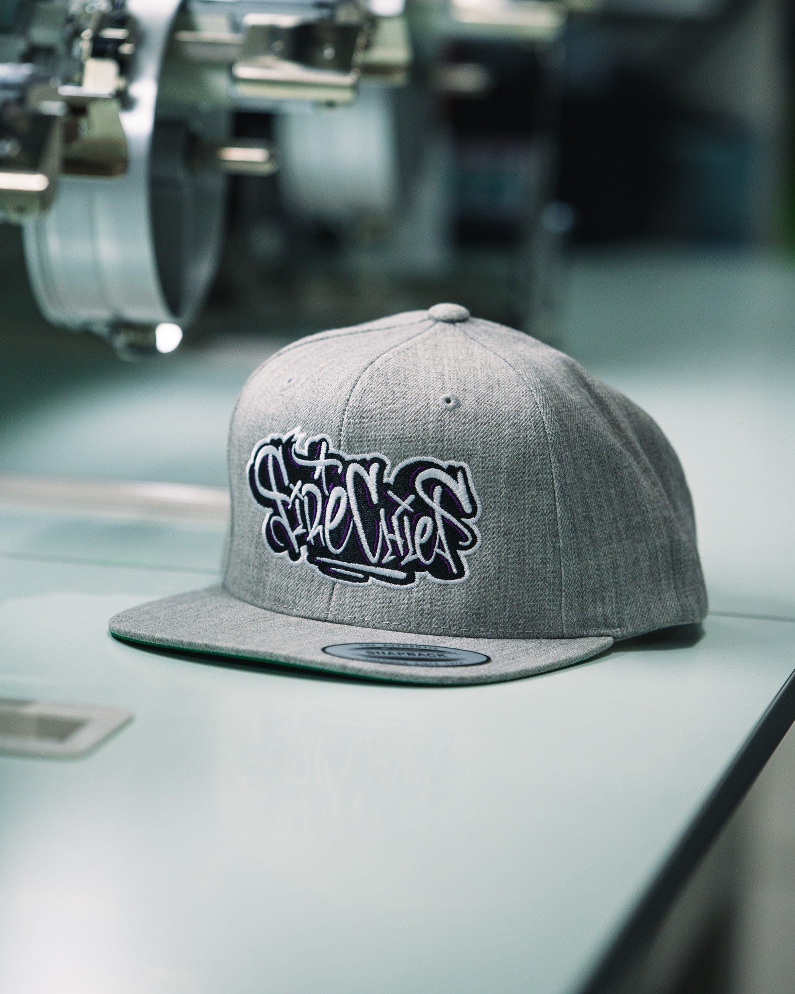 Custom embroidered grey snapback hat with graffiti-style “Fire Chief” lettering by Rogue Lab in Winnipeg, Manitoba
