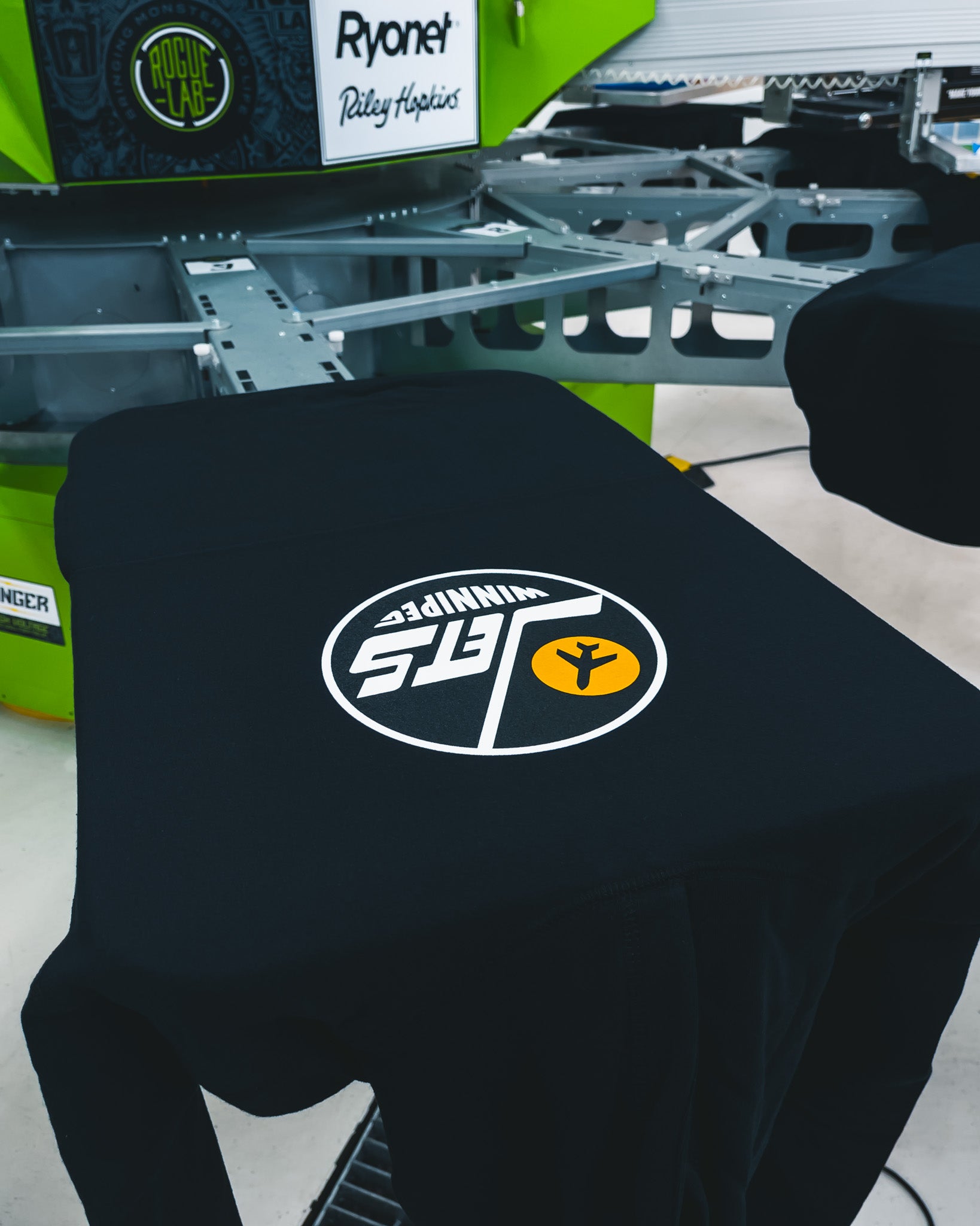 Custom screen printed black t-shirt with Winnipeg Jets-inspired logo by Rogue Lab on Riley Hopkins press in Winnipeg, Manitoba