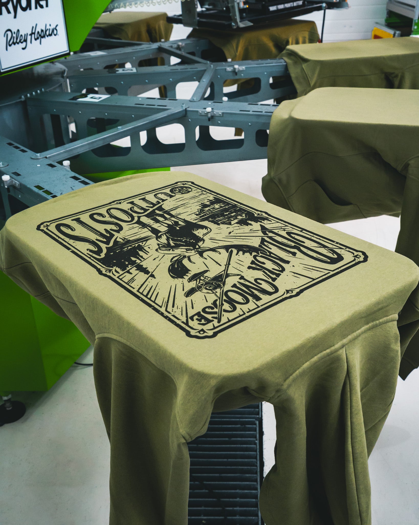 Custom screen printed olive green hoodie with black moose illustration and vintage graphic by Rogue Lab in Winnipeg, Manitoba